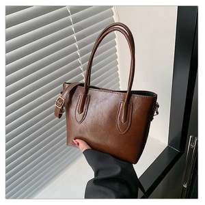 Detail of dark brown wax leather tote bag with vintage gold hardware and adjustable strap
