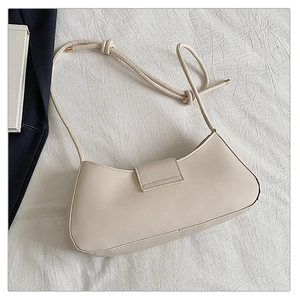 Détail du sac à bandoulière beige en similicuir avec lanière nouée et fermoir doré