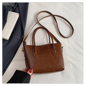 Detail view of the brown PU leather tote bag with glossy finish and adjustable strap