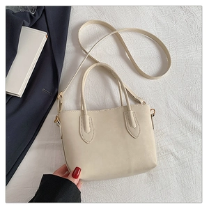 Top-down view of cream leather tote bag featuring sturdy handles and adjustable strap