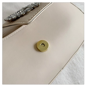 Gros plan des strass rectangulaires et du fermoir magnétique doré sur sac en cuir