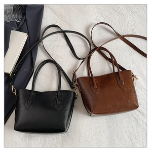 Flat lay of black and brown leather tote bags with handles and adjustable shoulder straps