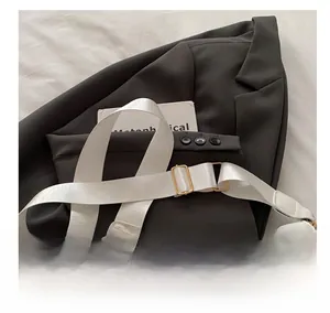 Detail showing the comfortable wide fabric shoulder strap and golden metal buckle
