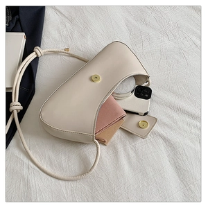 Détail de l'intérieur d'un sac crème montrant l'espace pour téléphone et portefeuille