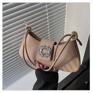 Détail du sac à bandoulière beige avec boucle en strass brillante et fine bandoulière corde