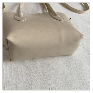 Detail view of large minimalist tote bag with retro cracked leather texture and wide base