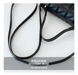 Detail of adjustable shoulder strap with gold-tone hardware on black quilted crossbody bag