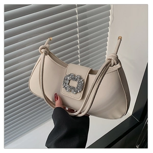 Détail du sac demi-lune blanc cassé avec boucle en strass scintillants et bandoulière nouée