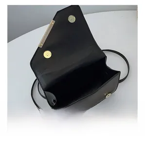 Detailed view of black leather bag interior with gold magnetic snap and metal hardware