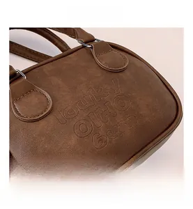 Détail du sac en cuir marron vintage avec texte Lucky OHIO gaufré et boucles en métal