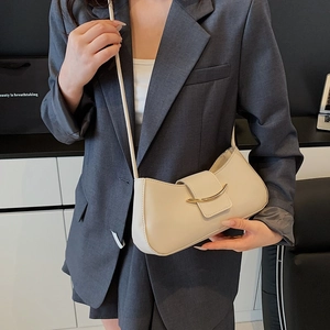 Chic cream half-moon crossbody bag with gold hardware shown on model in studio