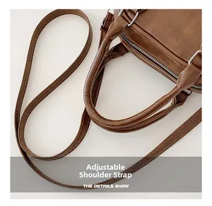Détails de la bandoulière réglable et des ferrures argentées sur un sac à main brun