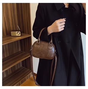Gros plan sur le gaufrage Lucky Emo Girl du sac à main vintage en similicuir marron