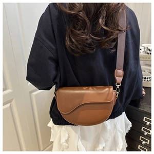 Brown matte PU leather saddle bag with wide fabric strap shown as a crossbody on a model