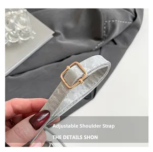Detail of adjustable gray leather strap with marble texture and gold metal buckle