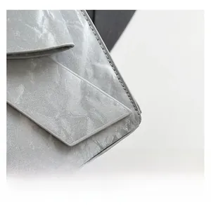 Close-up of silver pleated metallic fabric with fine stitching on a fashion handbag