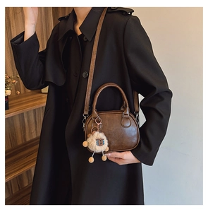 Sac cylindre marron avec gaufrage lucky WHO et détail de pendentif mouton en peluche