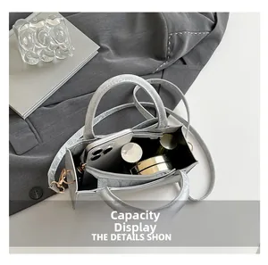 Top view of metallic grey handbag showing internal capacity for phone and cosmetics