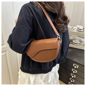 Brown saddle bag shown on model back view in a minimalist home setting decor