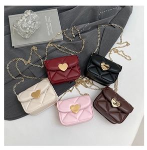 Flat lay of mini quilted crossbody bags in five colors with gold heart-shaped buckles