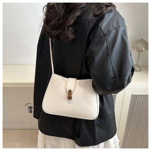 Rear view of a model wearing a white PU leather shoulder bag with vintage metal buckle