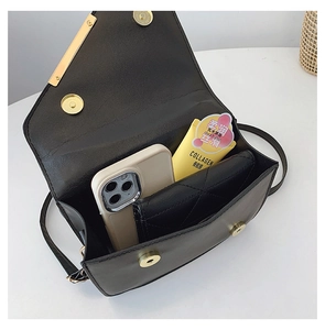 Interior view of black quilted crossbody bag showing storage space for phone and wallet