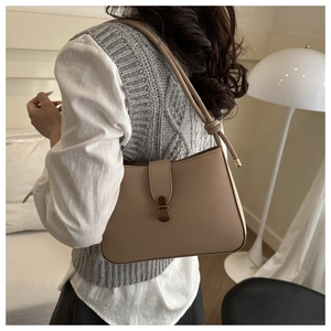 Detail of vintage khaki shoulder bag featuring metal buckle and unique knot shoulder strap