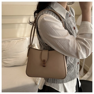Dettaglio della borsa sottobraccio beige con tracolla a nodo e fibbia in bronzo