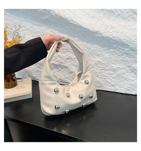 Detail of hobo bag featuring silver ball rivet studs and soft cream white PU leather texture