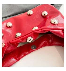 Detail of red wrinkled leather shoulder bag with silver studs and magnetic buckle