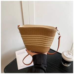 Gros plan sur la texture tissée et les rayures du sac seau en paille tressée