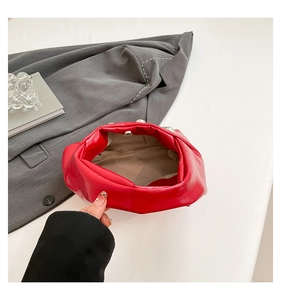 Interior view of a red leather clutch with magnetic buckle and pearl edge accents