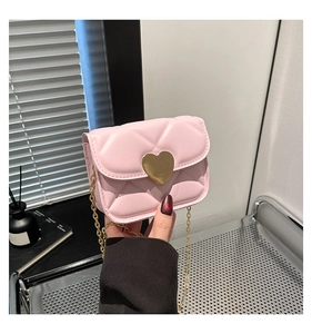 Detail of light pink quilted mini bag with golden heart clasp and chain strap