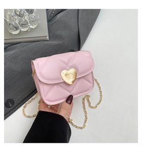 Detail of pink quilted mini bag with gold heart-shaped twist lock and chain strap