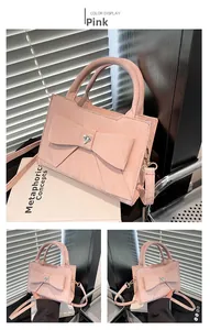 Detail of pink bow handbag with heart crystal and detachable golden hardware strap