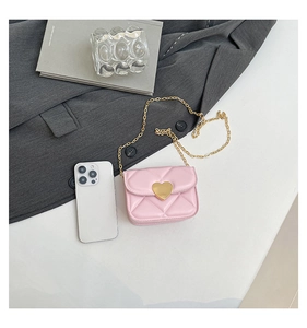 Detail of pink quilted mini crossbody bag with gold heart clasp and chain strap