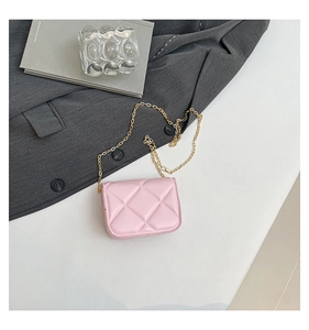 Detailed close-up of pink quilted mini crossbody bag with golden chain strap on a blazer