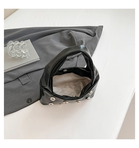 Top view of black patent leather bag featuring silver stud details and magnetic closure