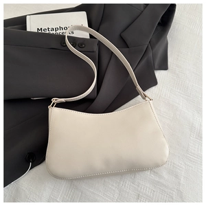Dettaglio della borsa baguette in ecopelle bianco crema con finiture in metallo dorato