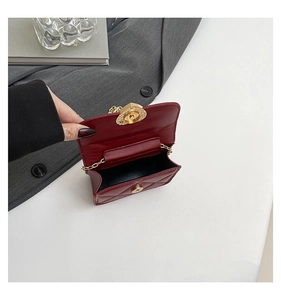 Detailed view of red quilted mini bag featuring heart-shaped gold clasp and chain strap
