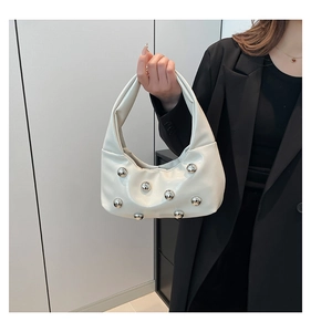Vue détaillée du sac croissant blanc orné de rivets argentés sur similicuir poli