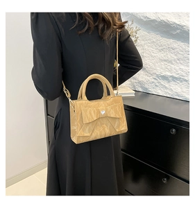 Sac à main kaki avec nœud et cristal cœur porté en bandoulière par un modèle