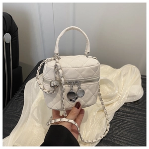Detail of white quilted mini handbag with silver chain strap and metallic charms