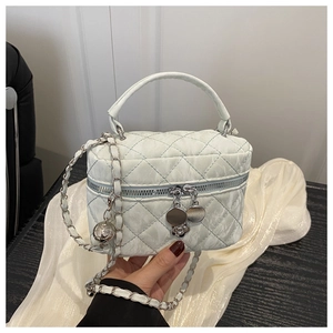Detail of mint green quilted chain bag with floral charms and dual zipper closure