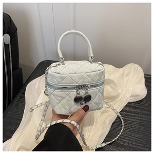 Close-up of light blue quilted mini bag with double zippers and chain strap detail