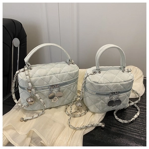 Close-up of mint green quilted handbags with silver chain straps in two sizes