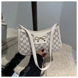 Dettaglio borsa baguette bianco off-white con motivo monogramma M e fiocco dorato