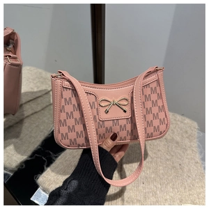 Dettaglio della borsa sottobraccio in PU rosa con motivo M e fiocco dorato