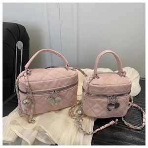 Detail of pink quilted velvet handbag with chain strap and camellia metal pendant