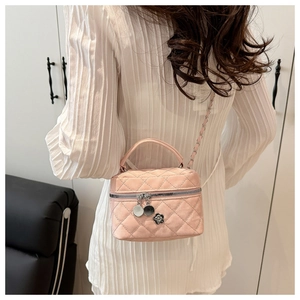 Detail of pink quilted mini handbag with camellia charm and silver chain strap